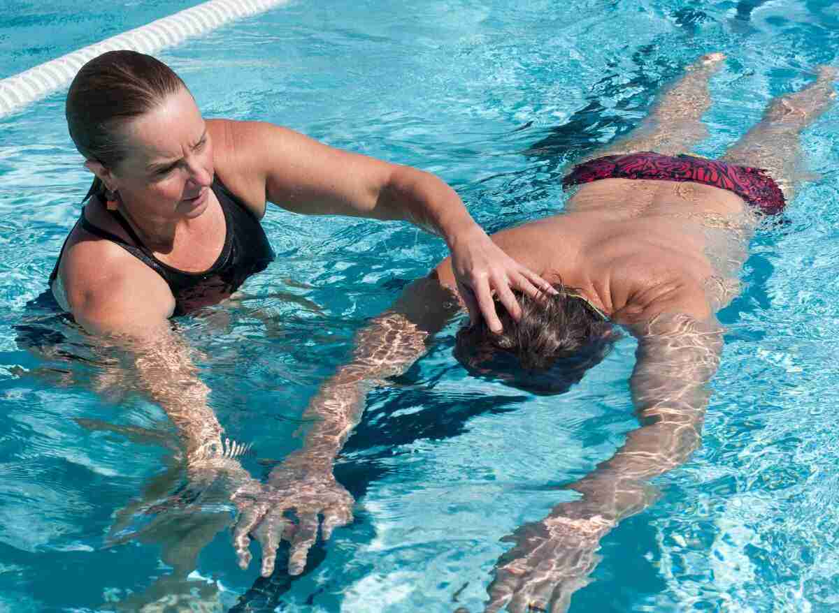 Am swimming перевод. A man teaching a woman swimming.